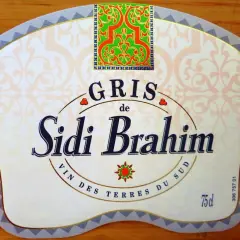 Étiquette de vin Sidi Brahim Gris, avec un motif floral vert et rouge en haut. Le texte "Sidi Brahim" est en gros caractères bleus.