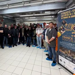 Une équipe de bouchers pose devant une bannière "Équipe de France Boucherie". Une idée de préparation boucherie pour le championnat du monde.