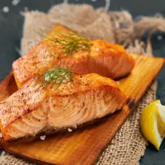 Deux pavés de saumon grillé, parsemés de sel et d'aneth, servis avec des quartiers de citron. Un délice pour accompagner un vin blanc.