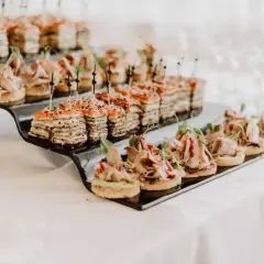 Petits fours variés sur un plateau noir, parfaits pour un mariage avec un budget alcool maîtrisé.