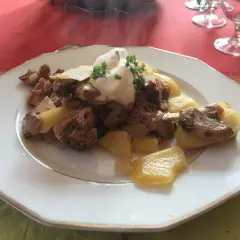 Un plat de baeckeoffe fumant, garni de crème et de persil. Quel vin avec baeckeoffe ? Un Riesling d'Alsace serait parfait.