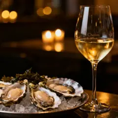 Un verre de vin blanc frais et des huîtres sur glace. Le parfait accord pour des fruits de mer.