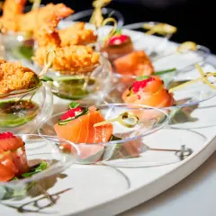 Un plateau d'apéro dinatoire américain avec des crevettes croustillantes et des roulés de saumon aux œufs de poisson.