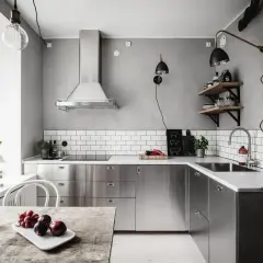 Cuisine moderne avec armoires en inox, parfait pour comment reconnaître de l'inox. Le plan de travail en marbre et le carrelage métro blanc complètent le look.