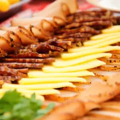 Un plat convivial à partager : fines tranches de charcuterie et de fromage, garni de persil frais.