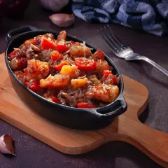 Plat mijoté de crevettes et tomates, garni de parmesan. Idéal pour apprendre comment dégraisser un plat et le rendre savoureux.