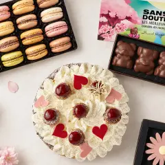 Un délicieux dessert pour la fête des grands-mères : une tarte garnie de fruits rouges et de crème, accompagnée de macarons colorés et de chocolats en forme d'oursons.