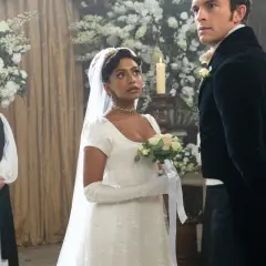 La mariée, le marié et le clergé se tiennent dans une église ornée de fleurs pour un mariage Bridgerton.