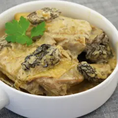 Un plat de poularde crémeuse aux morilles, garni de persil. Parfait pour savoir que servir avec une poularde au vin jaune.