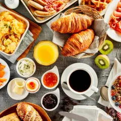 Un festin pour un brunch mariage : œufs brouillés, saumon fumé, croissants, fruits, café et granola.