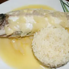 Un délicieux filet de loup au four, nappé d'une sauce au vin blanc et accompagné de riz.