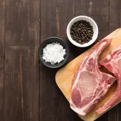 Deux belles côtes de porc rosé, prêtes à être assaisonnées de sel et de poivre noir en grains. Un délice à venir !