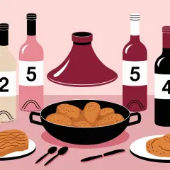 Bouteilles de vin numérotées et un plat de tajine poulet, prêt à être dégusté.