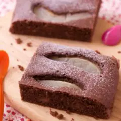 Gâteau au chocolat et poire, saupoudré de sucre glace. Une idée pour apporter un dessert original et gourmand.