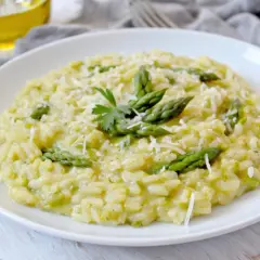Risotto crémeux aux asperges, parsemé de parmesan. Un délice qui invite à se demander : que boire avec un risotto ?