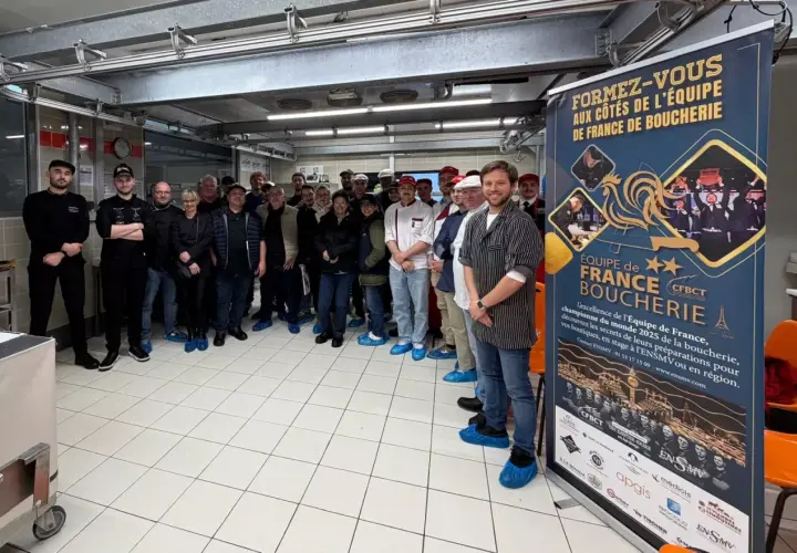 Une équipe de bouchers pose devant une bannière "Équipe de France Boucherie". Une idée de préparation boucherie pour le championnat du monde.