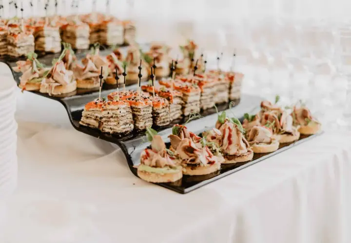 Petits fours variés sur un plateau noir, parfaits pour un mariage avec un budget alcool maîtrisé.