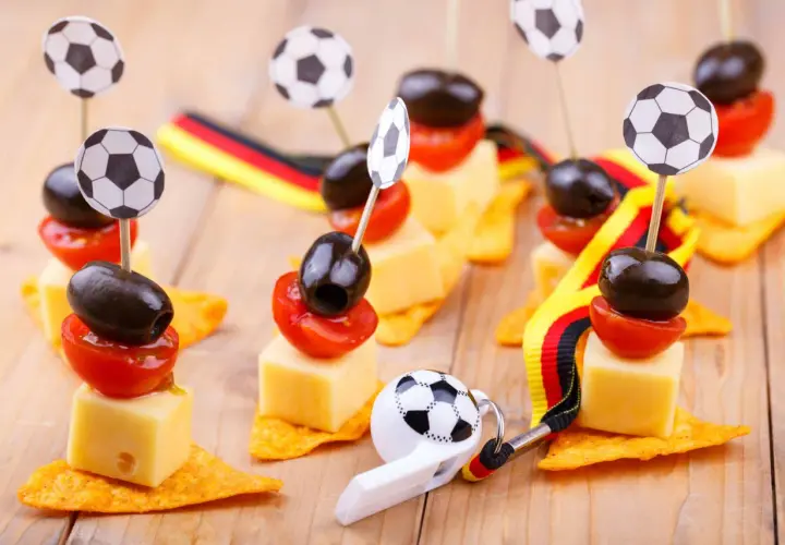 Ambiance parfaite pour une soiree foot : petits fours avec des ballons, des olives, des tomates et des drapeaux allemands.