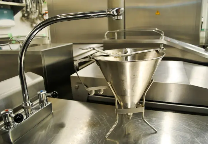 Un entonnoir à pâte en type inox, prêt à être utilisé dans une cuisine professionnelle.
