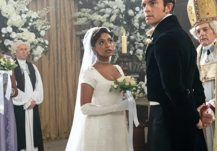 La mariée, le marié et le clergé se tiennent dans une église ornée de fleurs pour un mariage Bridgerton.