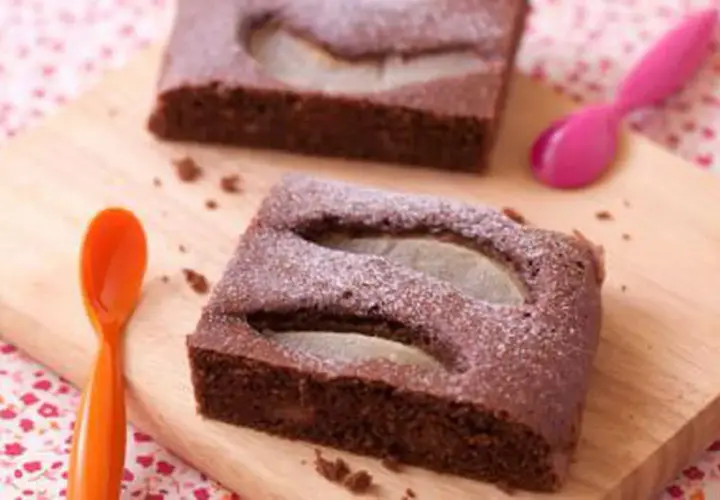 Gâteau au chocolat et poire, saupoudré de sucre glace. Une idée pour apporter un dessert original et gourmand.