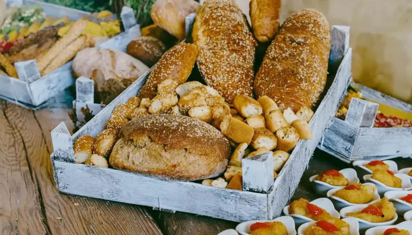 Plateau de pains variés, idéal pour organiser un petit déjeuner pour 30 personnes. Des miches rondes, des baguettes aux graines de sésame et des petits pains croustillants.