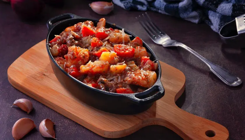 Plat mijoté de crevettes et tomates, garni de parmesan. Idéal pour apprendre comment dégraisser un plat et le rendre savoureux.