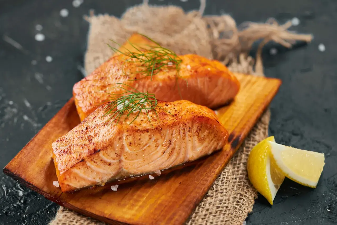Deux pavés de saumon grillé, parsemés de sel et d'aneth, servis avec des quartiers de citron. Un délice pour accompagner un vin blanc.