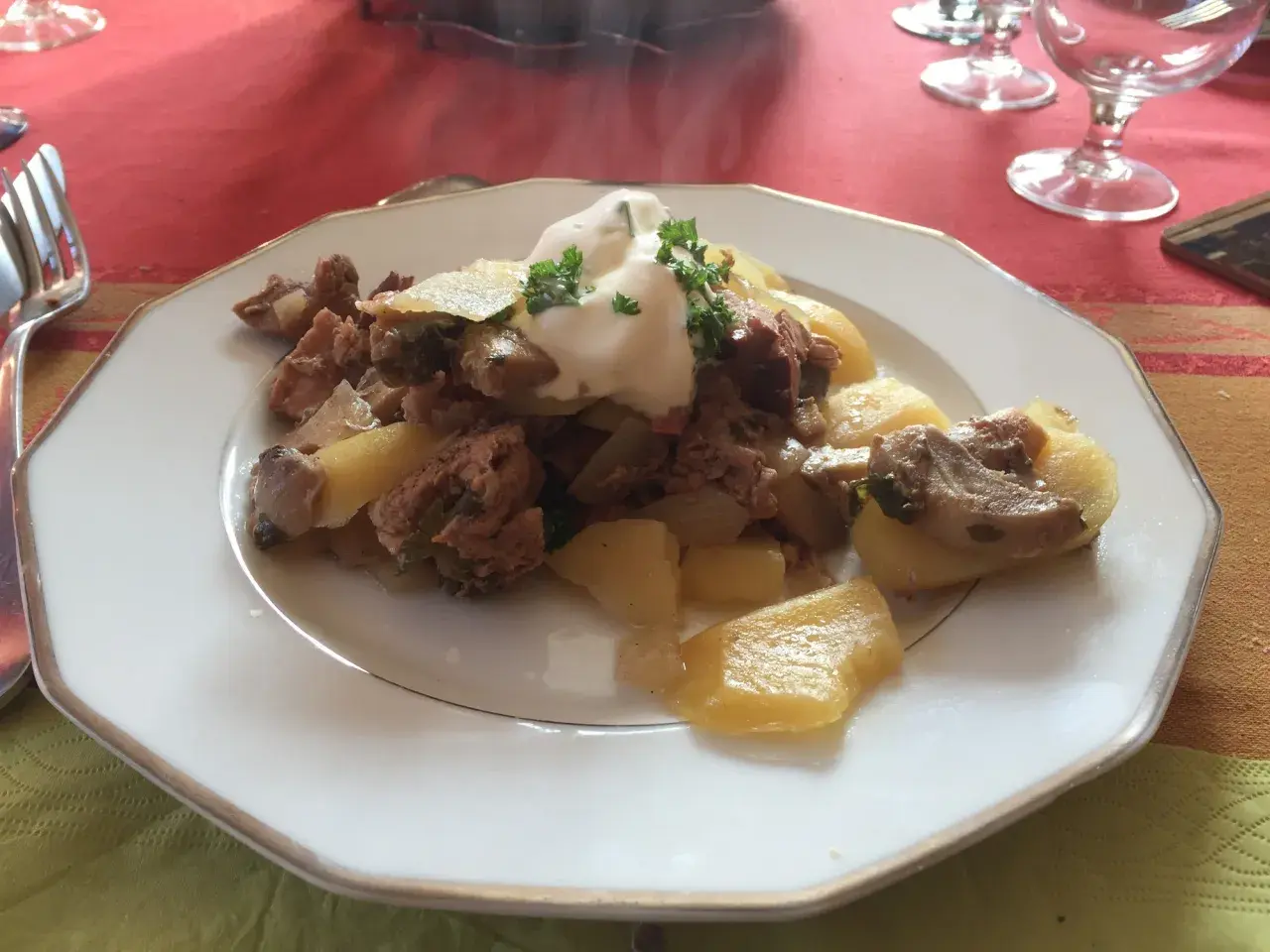 Un plat de baeckeoffe fumant, garni de crème et de persil. Quel vin avec baeckeoffe ? Un Riesling d'Alsace serait parfait.