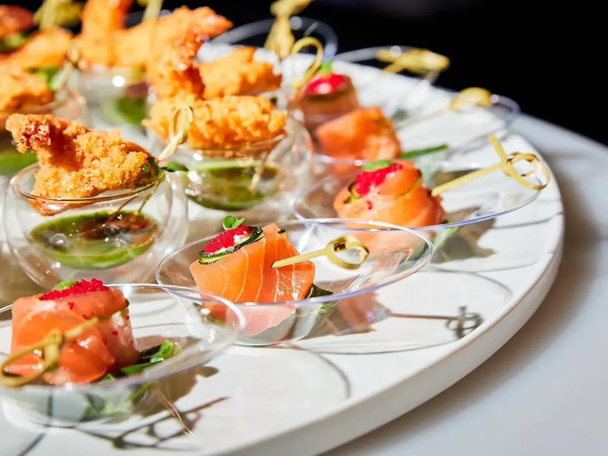 Un plateau d'apéro dinatoire américain avec des crevettes croustillantes et des roulés de saumon aux œufs de poisson.