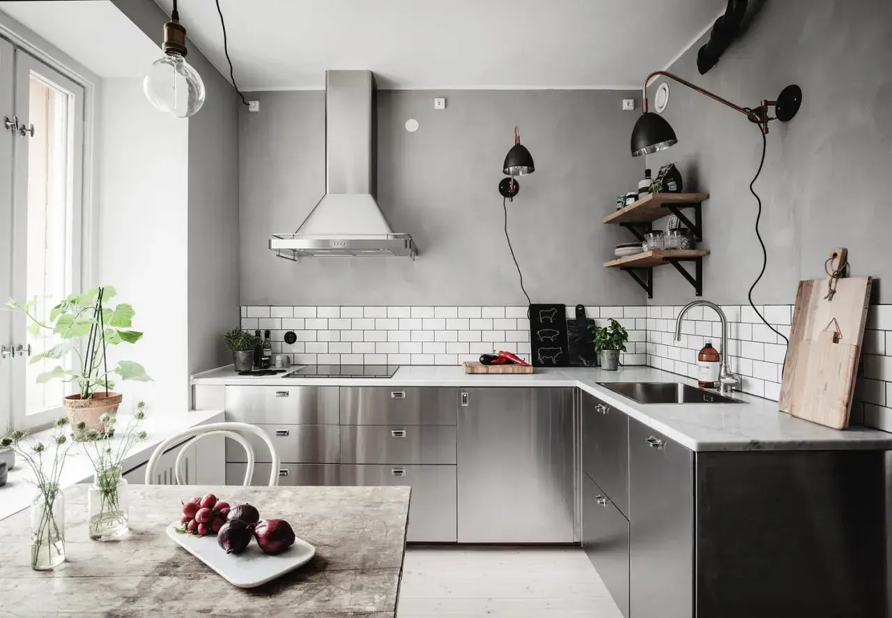 Cuisine moderne avec armoires en inox, parfait pour comment reconnaître de l'inox. Le plan de travail en marbre et le carrelage métro blanc complètent le look.