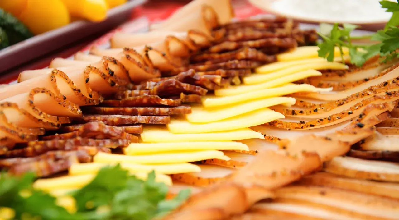 Un plat convivial à partager : fines tranches de charcuterie et de fromage, garni de persil frais.