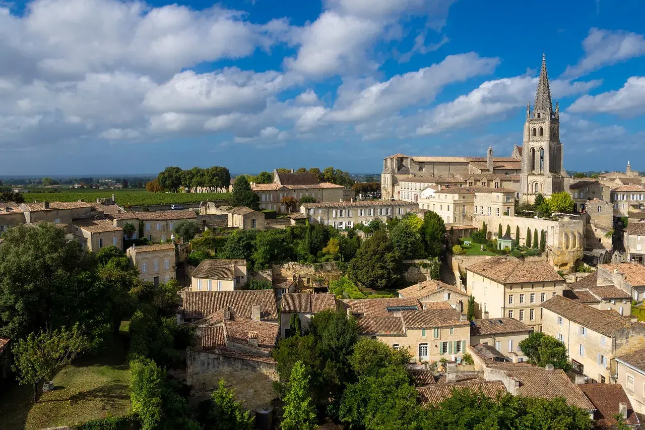 Vue aérienne de Saint-Émilion, ses toits de tuiles et sa collégiale, évoquant les meilleures années Saint-Émilion Grand Cru.