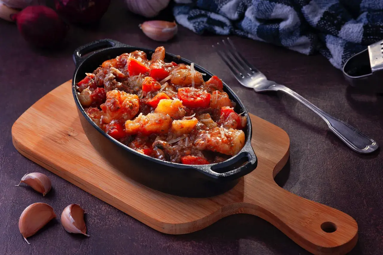 Plat mijoté de crevettes et tomates, garni de parmesan. Idéal pour apprendre comment dégraisser un plat et le rendre savoureux.