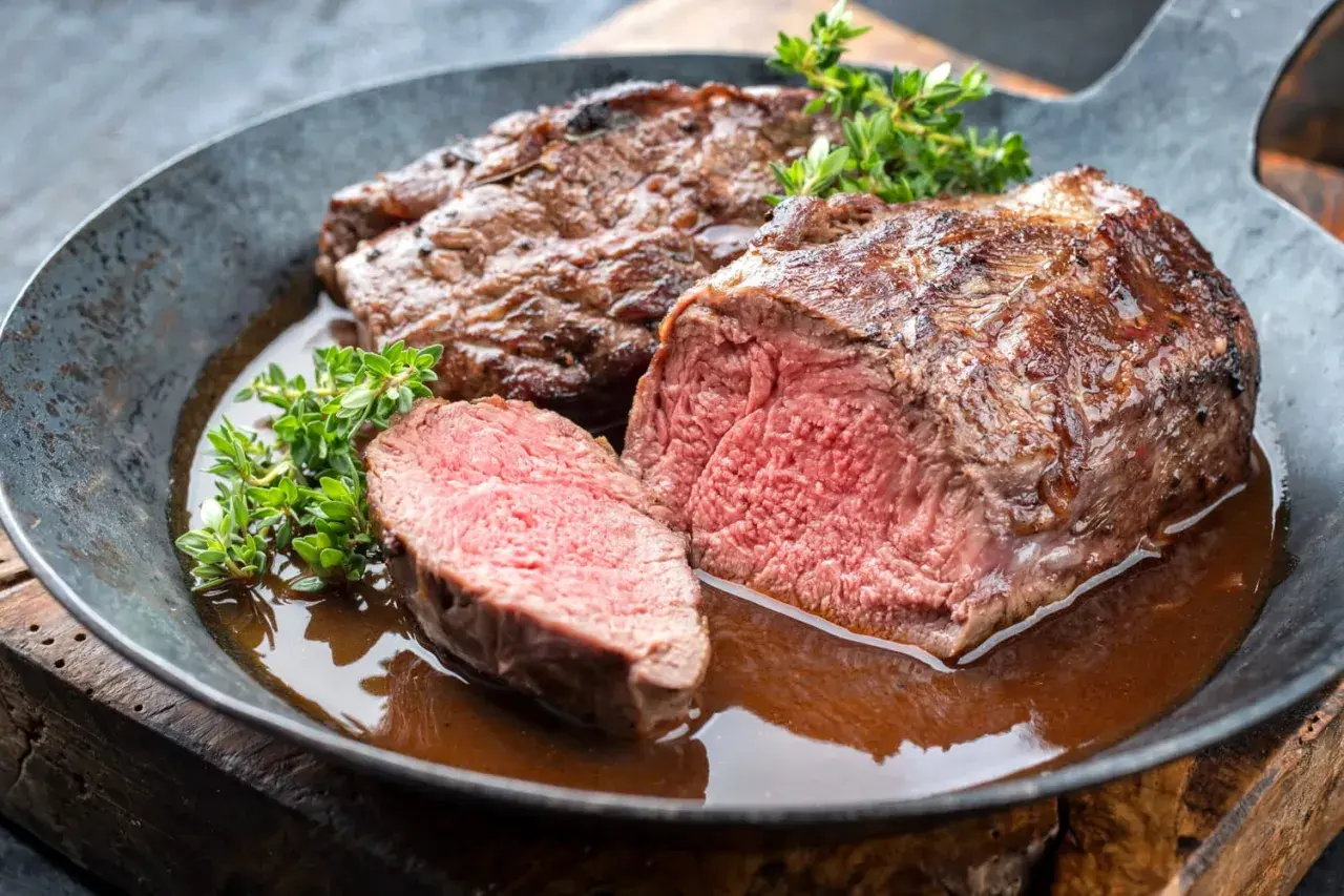 Un rôti de chevreuil juteux, coupé en tranches, baignant dans une sauce savoureuse. Un plat qui invite à se demander quel vin avec du chevreuil serait le meilleur accord.