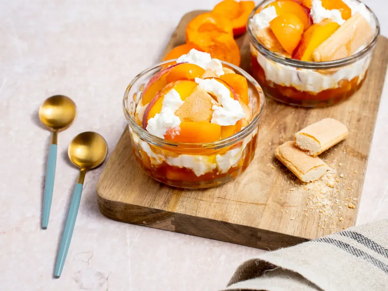 Délicieux dessert de saison septembre : verrines de fruits d'été et crème fouettée, parsemées de biscuits à la cuillère.