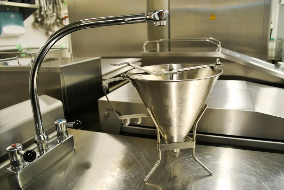 Un entonnoir à pâte en type inox, prêt à être utilisé dans une cuisine professionnelle.