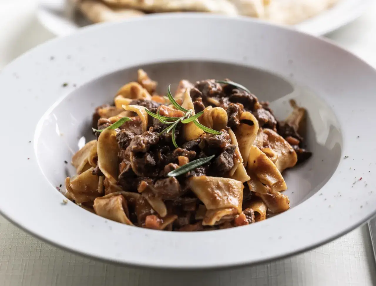 Pâtes fraîches avec un riche civet de bœuf mijoté au vin rouge, garni de romarin. Un plat réconfortant parfait pour les soirées d'automne.