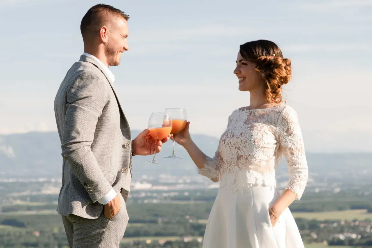 Jeune mariés trinquant avec des verres de boisson fruitée, une belle quantité pour célébrer leur amour.