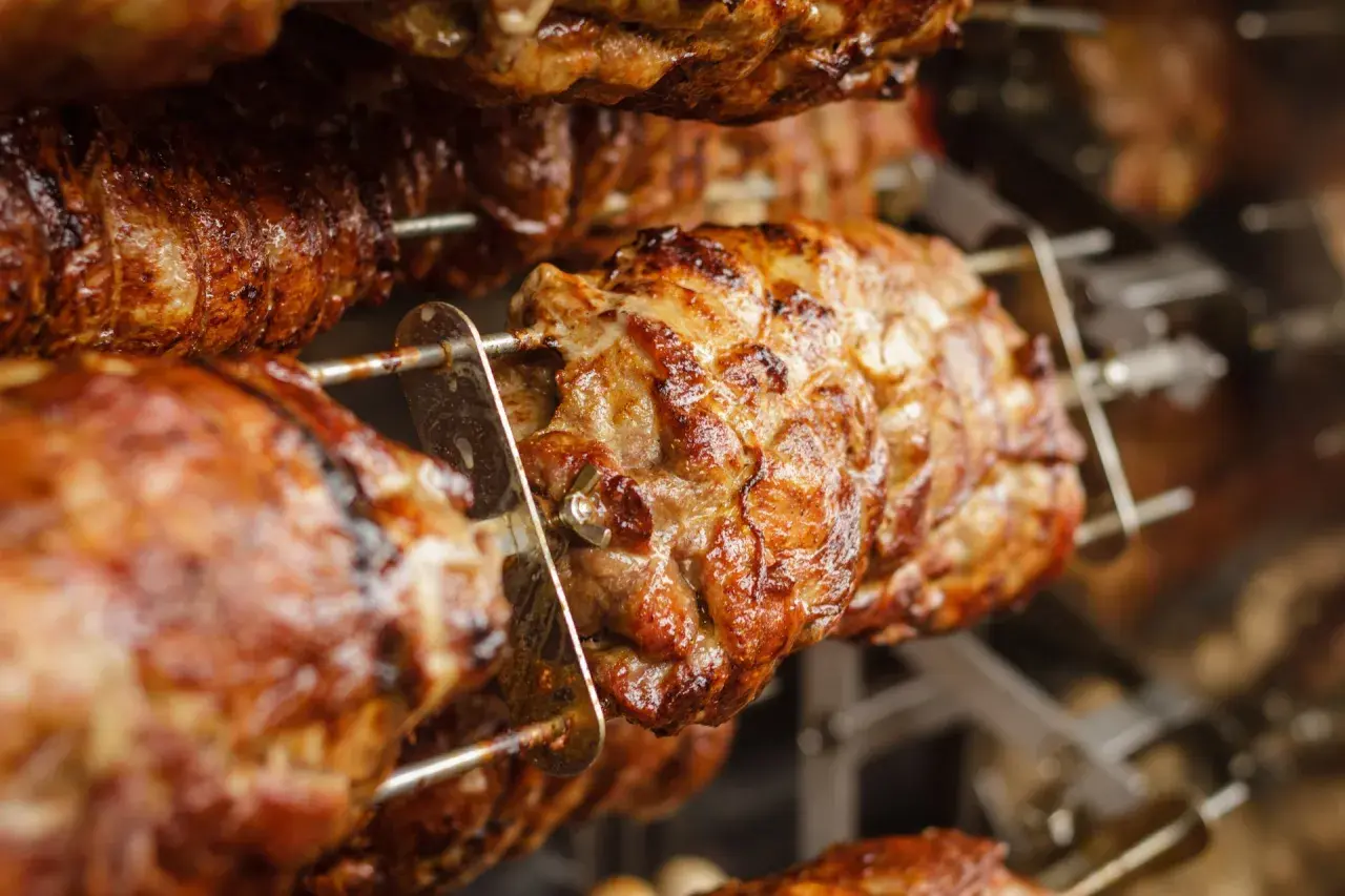 Cochon de lait grillé sur une rôtissoire. Quel vin avec cochon de lait grillé ? Un rouge fruité et léger serait parfait.