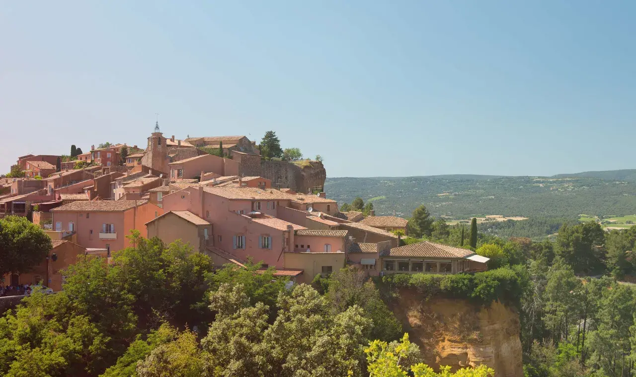 Village de Roussillon, terre du midi rosé, avec ses maisons ocres perchées sur une falaise. Un paysage provençal qui invite à la dégustation.