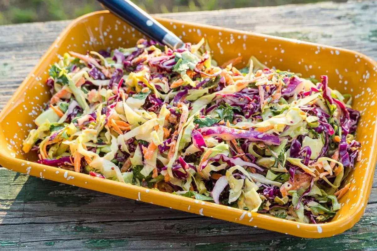Salade colorée de chou rouge et blanc, carottes râpées, et persil, parfaite en accompagnement effiloché de porc.