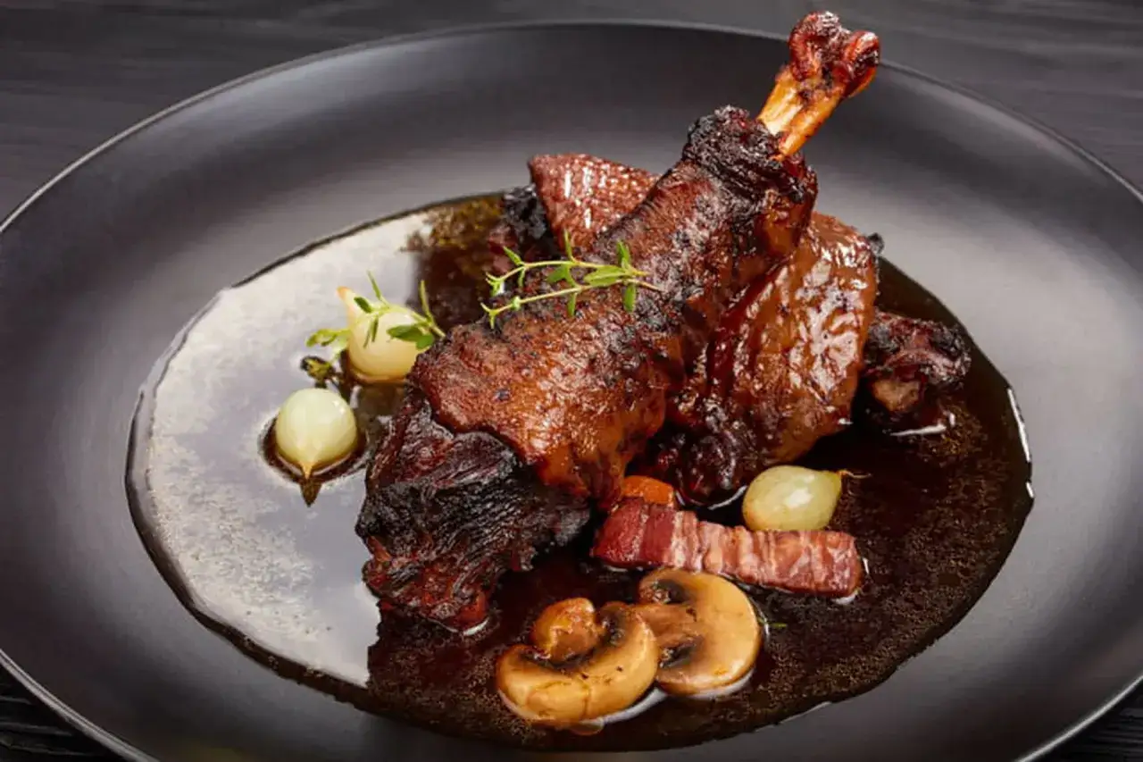 Coq au vin, un plat savoureux avec des morceaux de poulet braisés, des lardons, des champignons et des oignons. Quel vin pour un coq au vin ? Un Bourgogne rouge, bien sûr !