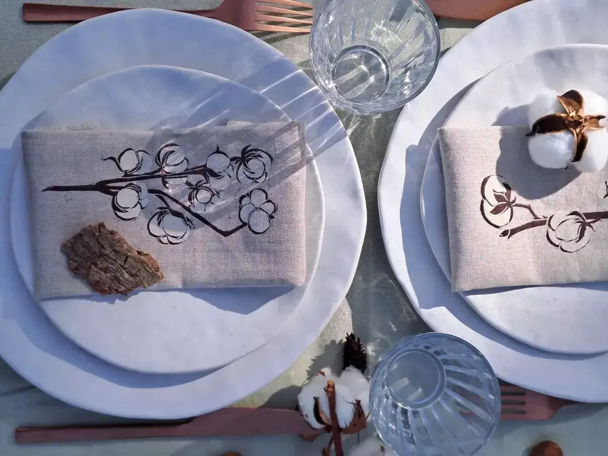 Table dressée pour une 1ere année de mariage, avec des serviettes ornées de coton et des touches naturelles.