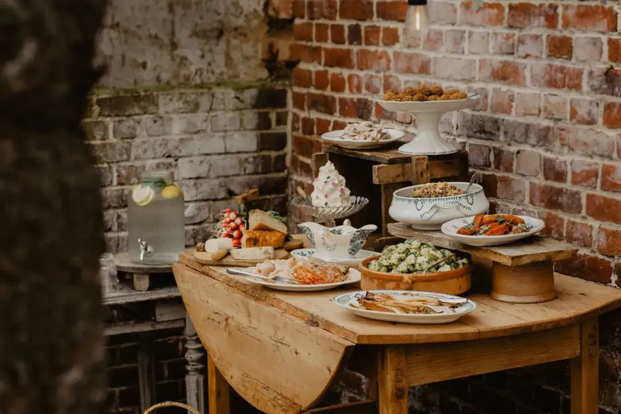 Un buffet campagnard pour 20 personnes : salades, charcuterie, fromages, pain, et une fontaine &agrave; eau citronn&eacute;e.