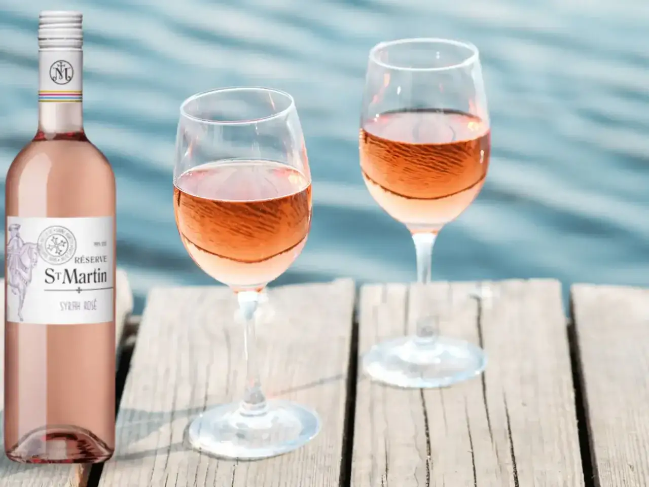 Bouteille et deux verres de rosé St Martin Syrah Rosé sur un ponton en bois. Avis sur ce vin du midi.