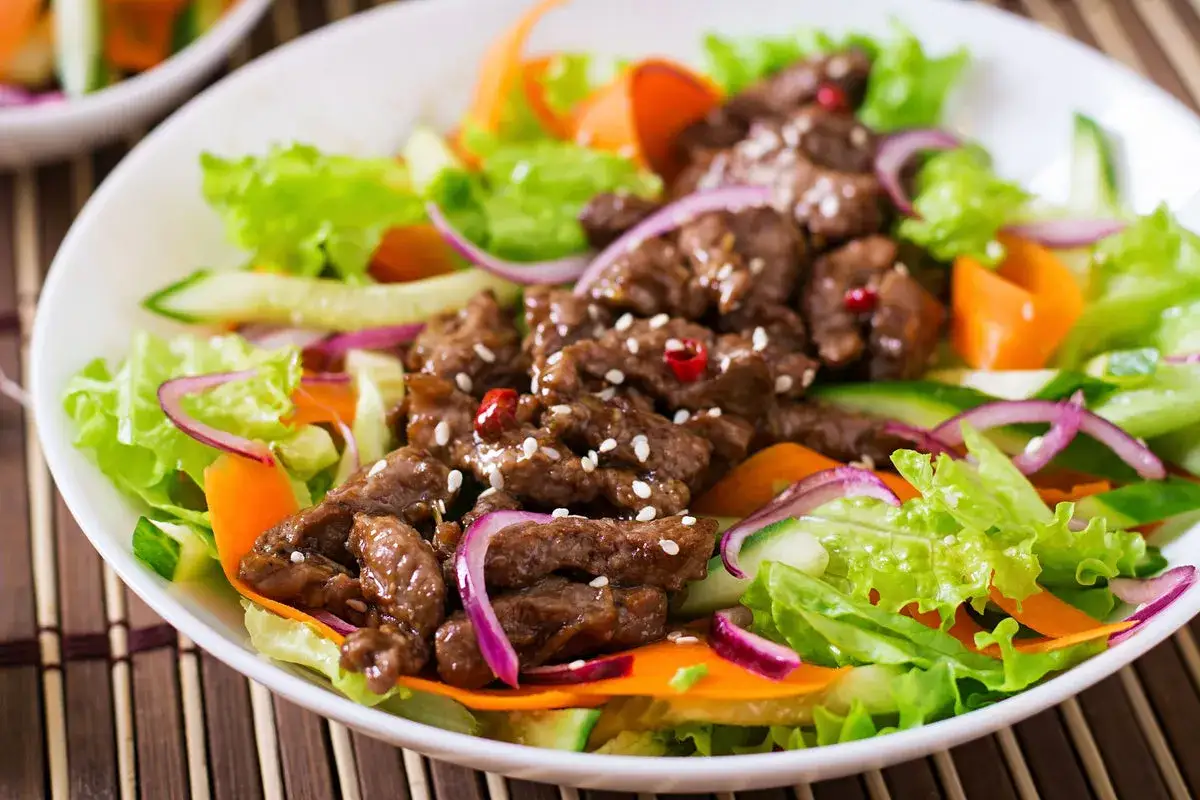 Salade de viandes froides savoureuse avec des lani&egrave;res de b&oelig;uf, des l&eacute;gumes croquants et des oignons rouges.