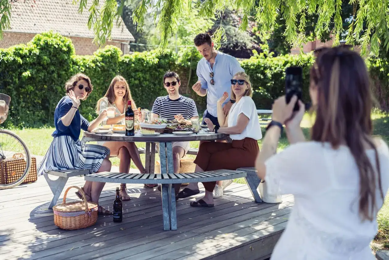 Amis profitent d'un pique-nique ensoleill&eacute;. Id&eacute;es de que prendre pour un picnic entre amis : salades, bouteille de Picon, et bonne humeur.