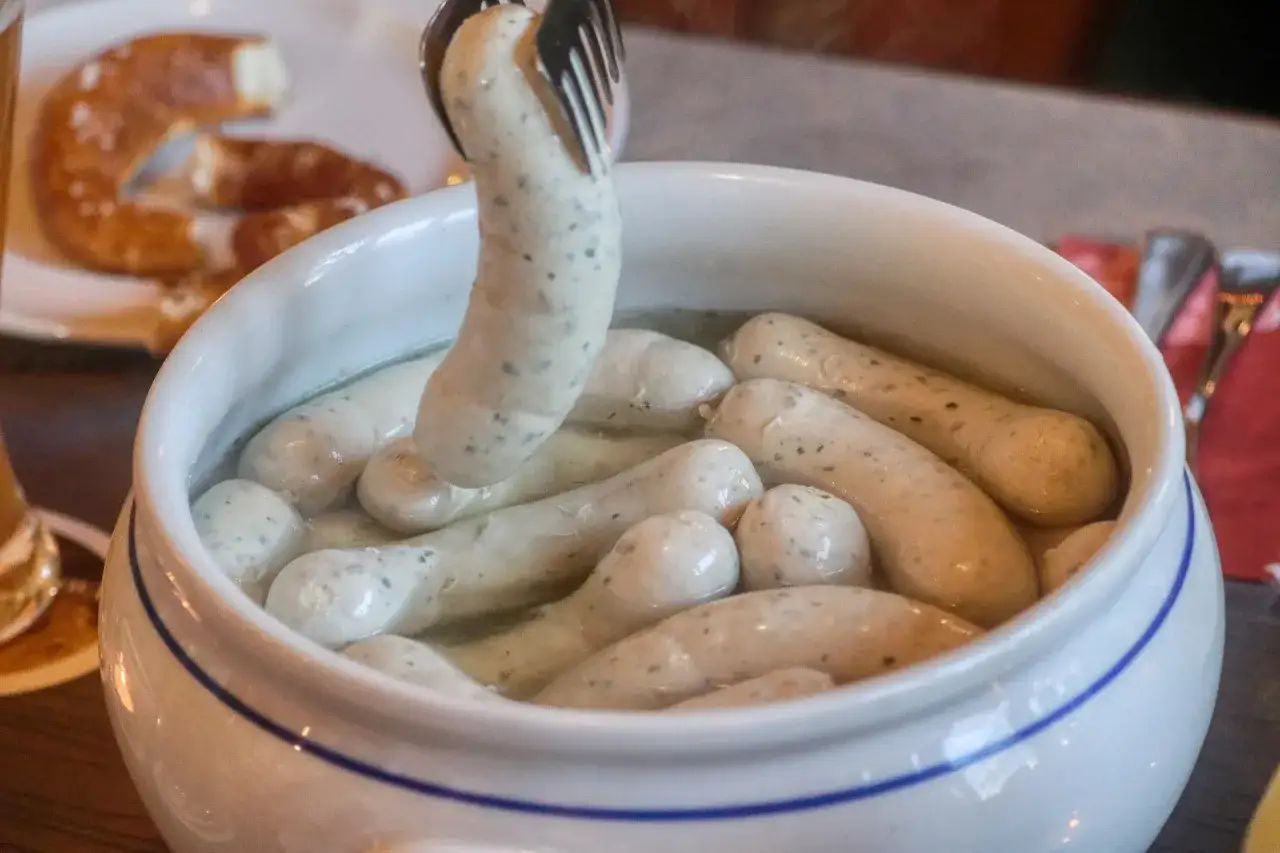 Boudin blanc poché dans un plat blanc, prêt à être dégusté. Quel vin avec du boudin blanc ? Un vin blanc sec et fruité serait parfait.