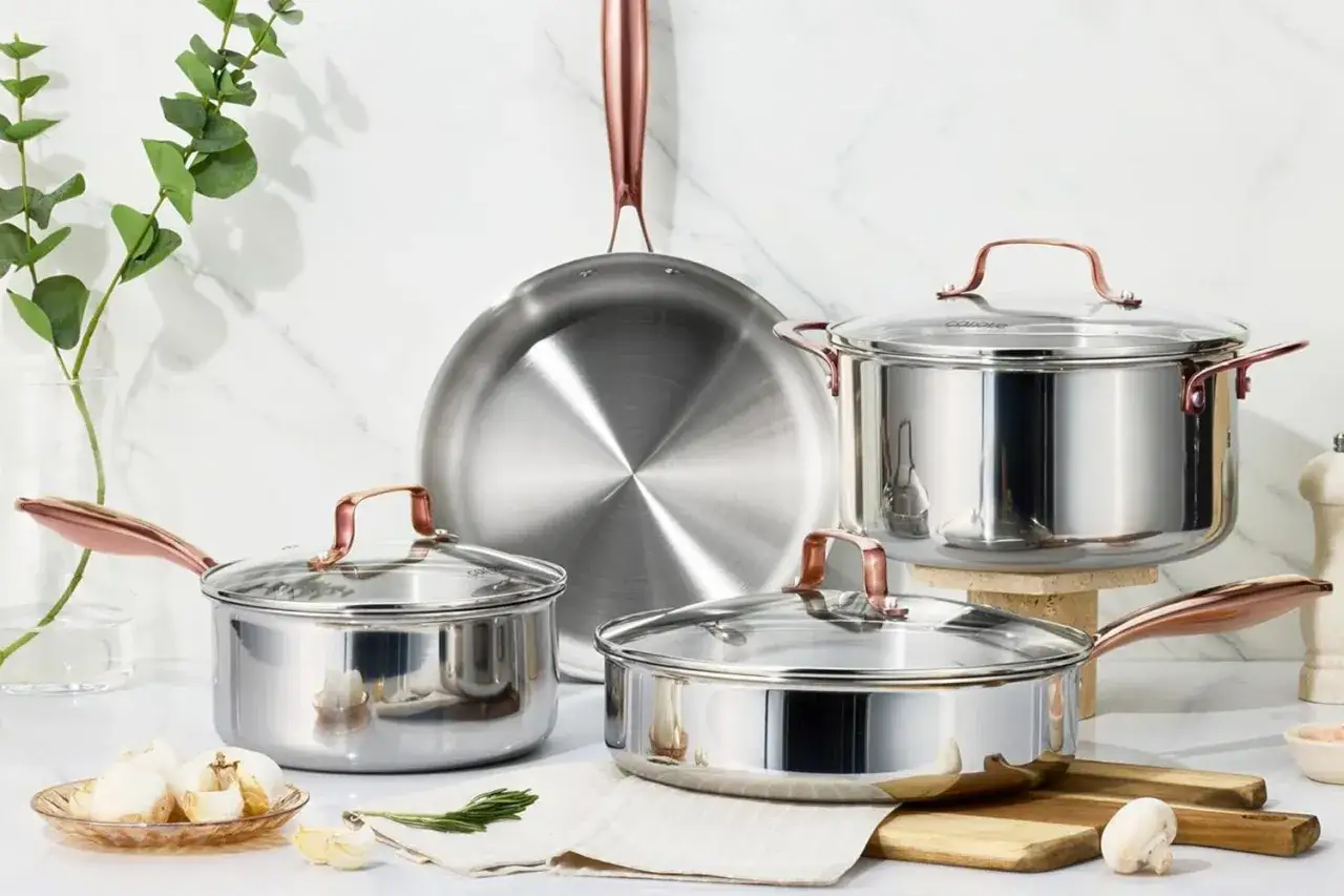 Ensemble de casseroles et poêles en inox avec poignées cuivrées. Attention, le poêle en inox peut être dangereux si mal utilisé.